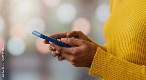 Fototapeta Woman's hands holding and interacting with a blue mobile phone