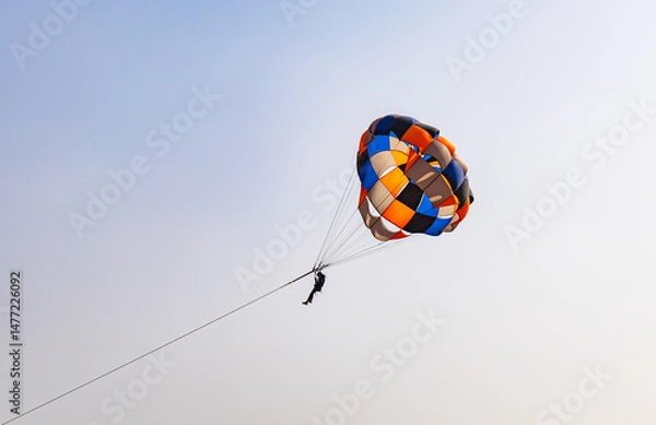Fototapeta parasailing adventure activity at desert with bright blue sky background at day from flat angle