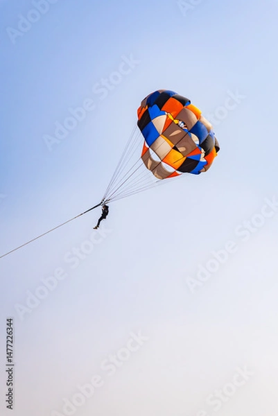 Fototapeta parasailing adventure activity at desert with bright blue sky background at day from flat angle