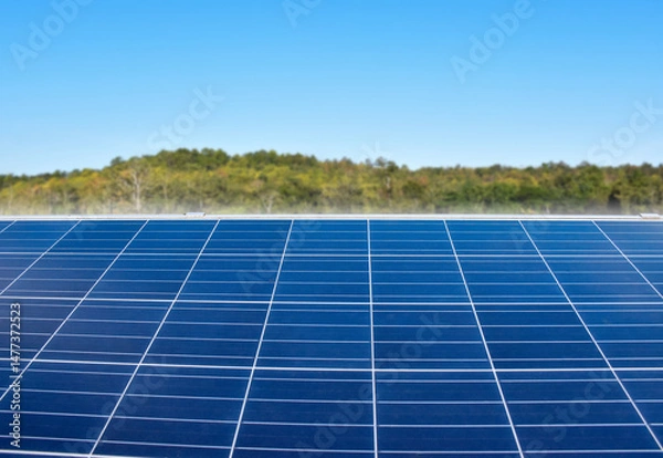 Fototapeta closeup photovoltaic panels which installed on the rooftop of the building, concept for storing and using natural power from the sunlight to care about human environment over the world.