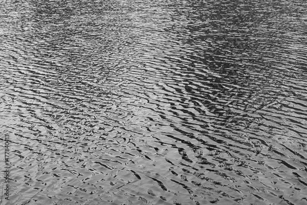 Fototapeta Water ripples on the surface of a lake in monochrome black and white