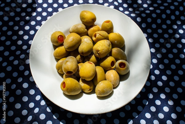 Obraz Green Olives in a Bowl on a polka dot table 