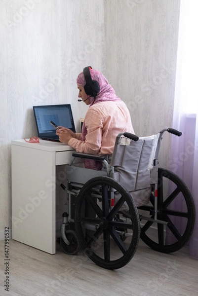 Fototapeta woman in muslim headscarf office style, working from home, disabled girl in wheelchair work from home, including disabled people