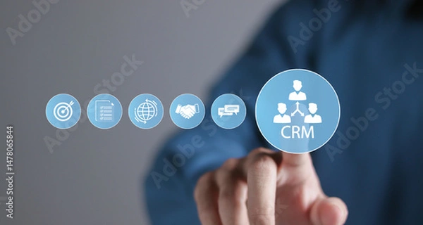 Fototapeta Customer relationship management software concept. CRM for sales, marketing and customer support. Person touching CRM icon on virtual screen.