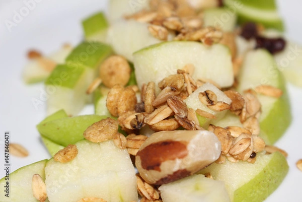 Fototapeta Chopped Green Apple with Granola Topping.  Green Apple and Crunchy Granola. Nutritious Snack: Diced Green Apple with Cereal Mix.