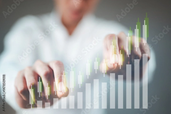 Fototapeta A businessman in a white shirt is tapping on an uptrend stock chart.