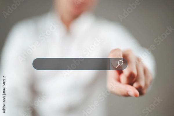 Fototapeta A man wearing a white shirt is pointing his index finger at the search button.