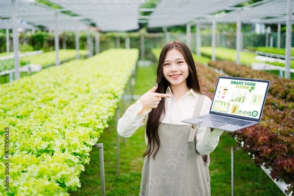 Obraz Young Woman Showcasing Smart Farm Technology in Greenhouse Setting