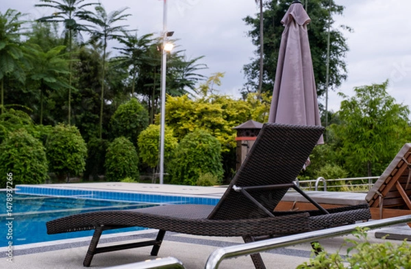 Fototapeta Sun bed chair on the edge of a hotel or resort swimming pool