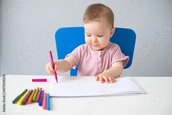 Obraz little girl draws with colored markers. Toddler development
