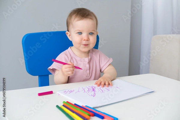 Obraz little girl draws with colored markers. Toddler development
