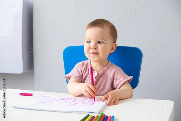 Obraz little girl draws with colored markers. Toddler development