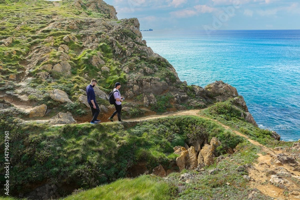 Obraz Two people walking through the landscape of the Costa Quebrada in Cantabria