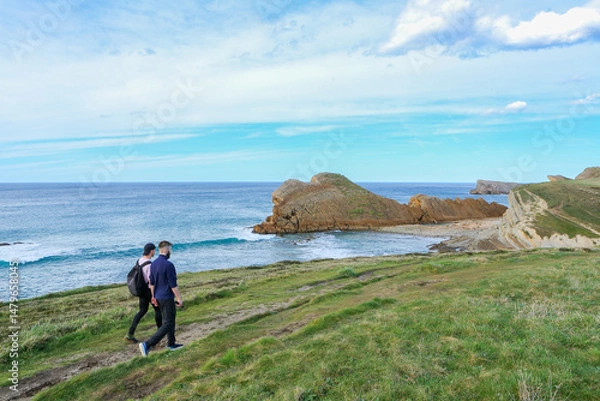Obraz Two people walking through the landscape of the Costa Quebrada in Cantabria