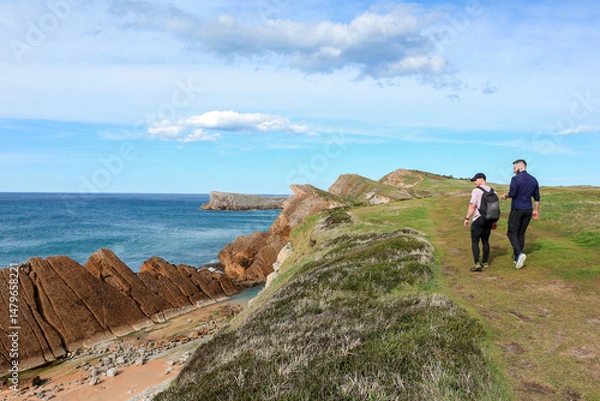 Obraz Two people walking through the landscape of the Costa Quebrada in Cantabria