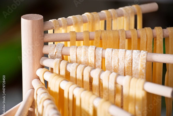 Obraz Homemade noodles hanging on wooden dryer rack closeup low angle view