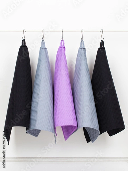Obraz cotton waffle towels for the kitchen hang on hooks on a bracket against a white wall background