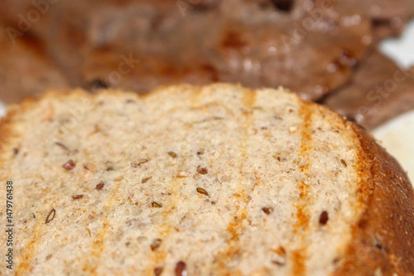 Fototapeta Whole Bread with Blurred Meat. Bread and Soft Focus Meat. selective focus meal.