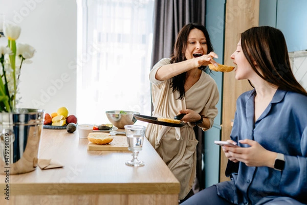 Obraz Playful breakfast moment between mom and daughter