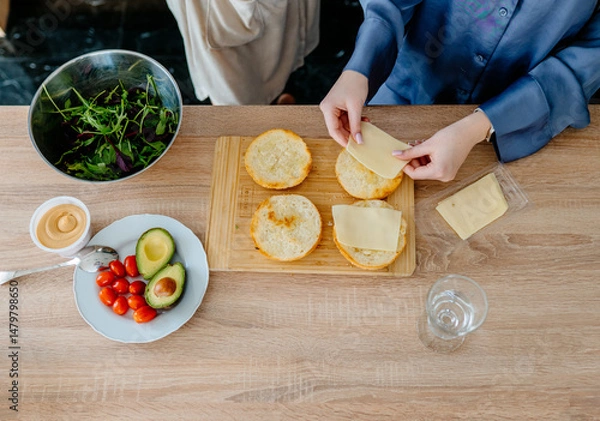 Obraz Top view of hands preparing sandwich with cheese slices