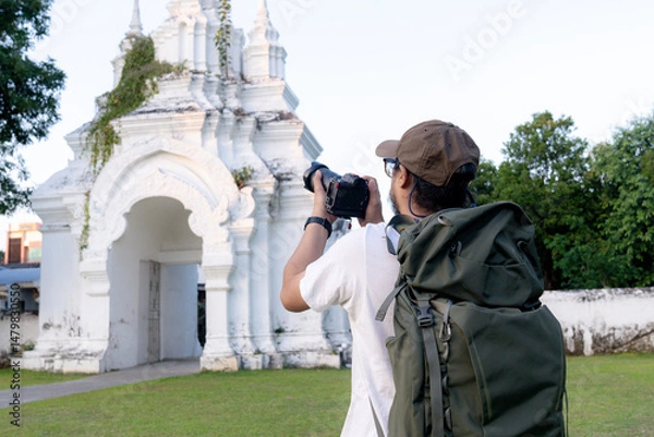 Fototapeta A lone traveler capturing memories through his lens, exploring the world one shot at a time.