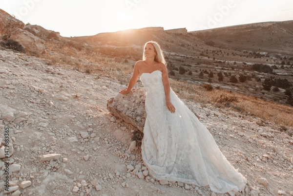 Obraz a woman in a white dress, a bride on a mountain with a blue sky. Beautiful nature, freedom, enjoyment of life. High quality photo