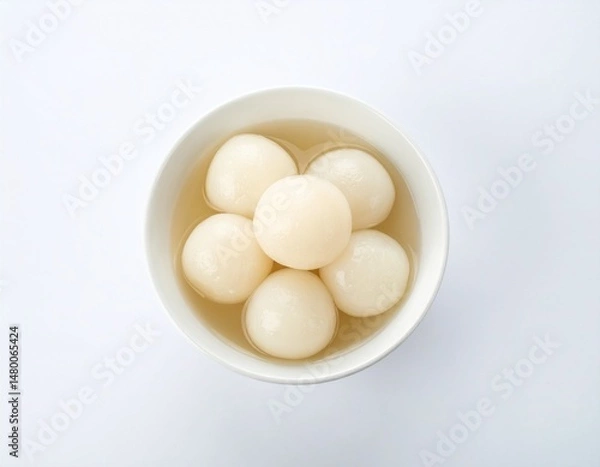 Fototapeta Sweet dumplings in syrup in a white bowl, viewed from above