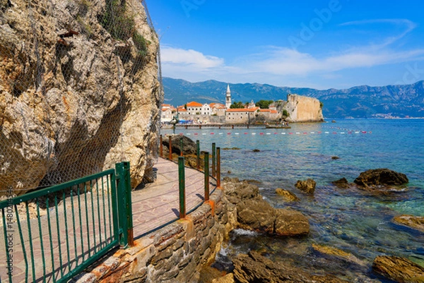 Fototapeta Waterside pathway to Mogren Beach nestled under a cliff on the Budva Riviera along the coast of the Adriatic Sea in Montenegro