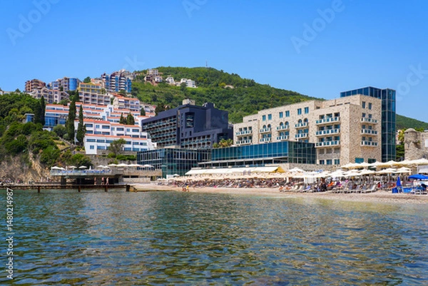 Fototapeta Plaža Ričardova Glava (Richard's Head Beach) overlooked by modern hotels near the Old Town of Budva on the coast of the Adriatic Sea in Montenegro