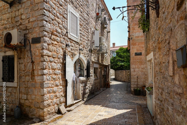 Fototapeta Narrow paved street in the Old Town of Budva, a walled coastal city built by the Venetian Republic along the coast of the Adriatic Sea in Montenegro