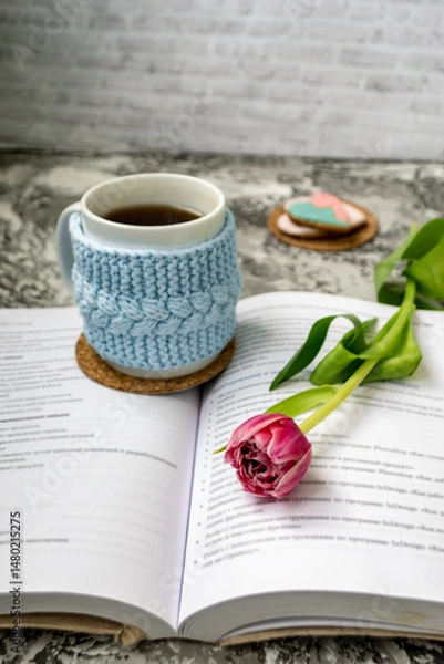 Fototapeta Pink tulips, an open book and a mug of freshly brewed coffee or tea. Spring set. Flatley layout.