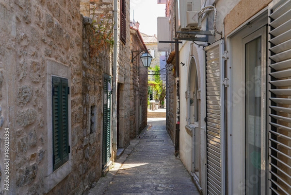 Fototapeta Narrow paved street in the Old Town of Budva, a walled coastal city built by the Venetian Republic along the coast of the Adriatic Sea in Montenegro