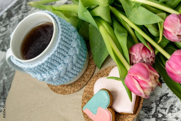 Fototapeta Pink tulips, an open book and a mug of freshly brewed coffee or tea. Spring set. Flatley layout.