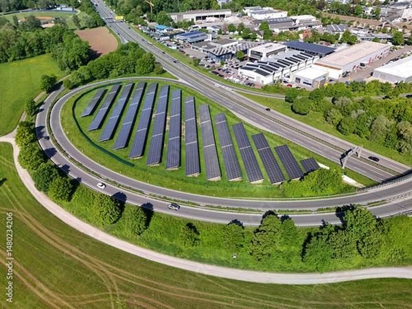 Obraz Aerial drone photo of large array of photovoltaic solar panels next to a motorway access