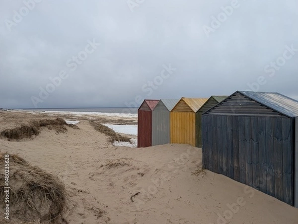 Obraz A vibrant and vivid row of colorful beach huts stands proudly on a sunkissed sandy beach, creating a picturesque seaside view