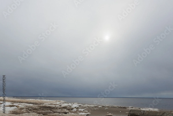 Obraz The bright sun is shining beautifully through the fluffy clouds hanging over the vast ocean, creating a picturesque scene