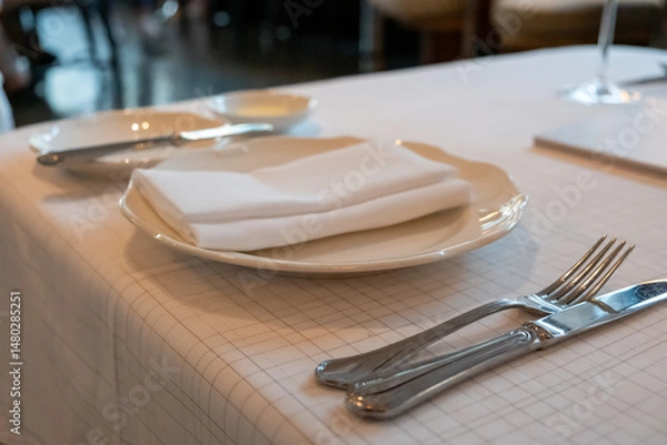 Fototapeta A set of spoon, fork, knife and plate prepared on the table, in the restaurant
