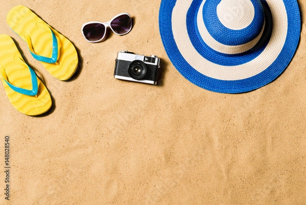 Fototapeta Pair of flip flop sandals, sunglasses, hat and camera.
