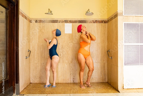 Fototapeta A young couple of girls enjoy a day at a spa.Women shower before entering a spa. Concept of hygiene in pools or wellness centers.Concept of beautiful women in a spa.