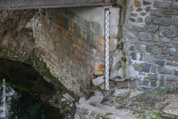 Fototapeta A numerical indicator on the side wall by the river.
