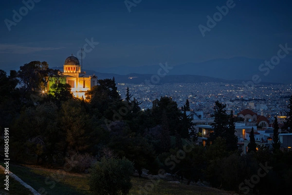 Fototapeta Scenic view of lit National Observatory of Athens and downtown of Athens in Greece at dusk. Urban skyline, metropolis and city view during blue hour.