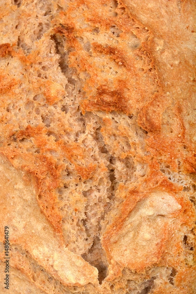 Fototapeta A detailed close-up captures the textured surface of a rustic sourdough bread loaf