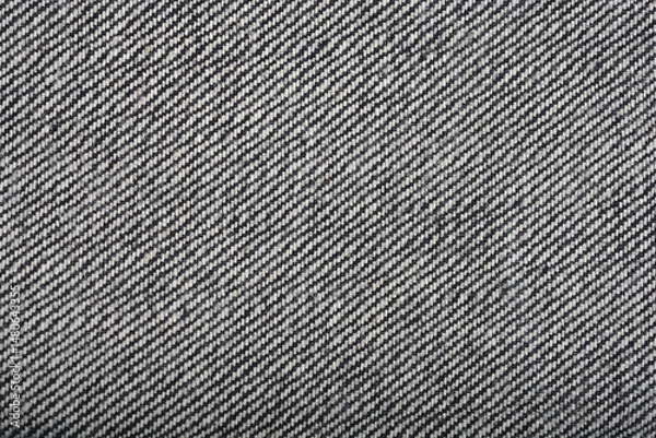 Fototapeta A close-up shows the textured underside of denim fabric with a diagonal twill pattern in shades of gray and black