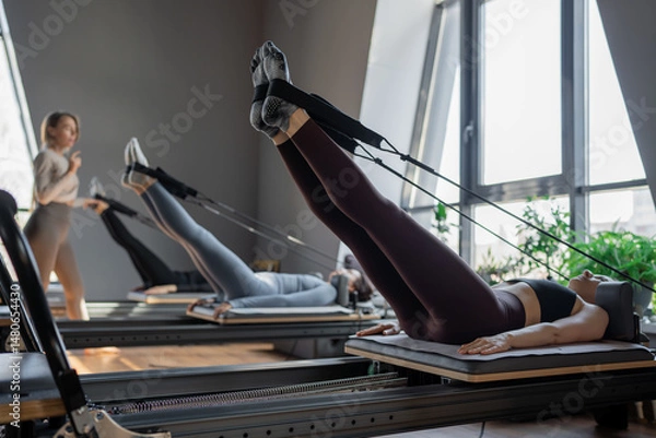 Fototapeta A detailed closeup of a foot work and core exercise on a Balanced Body Reformer machine illuminated by sunlight
