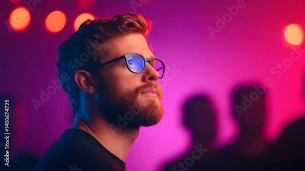 Obraz Portrait of a Man with Red Curly Hair and Beard Wearing Glasses in a Pink and Purple Lit Setting