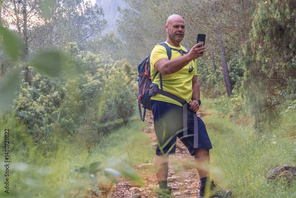 Obraz Man in the forest taking a selfie with the phone.