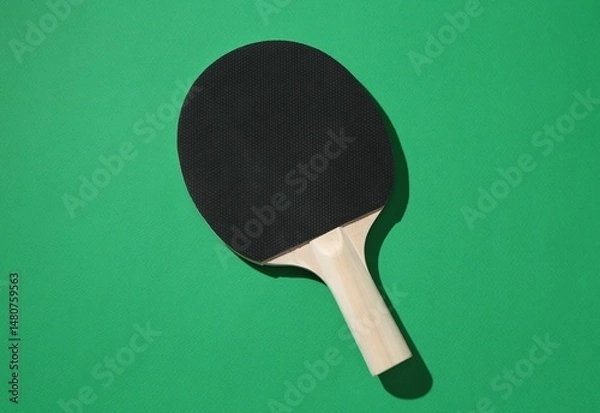 Fototapeta One ping pong racket on green background, top view