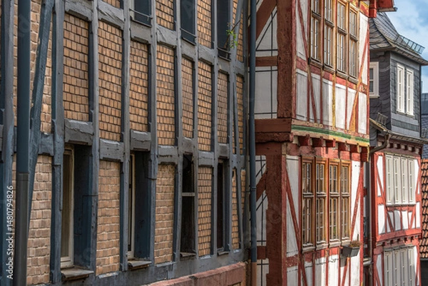 Obraz A diverse facade of historic half-timbered houses lined up next to each other in earthy tones