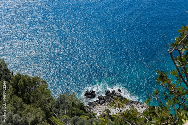 Fototapeta Beautiful view of the waves of the Tyrrhenian Sea on a summer day on the island of Capri.