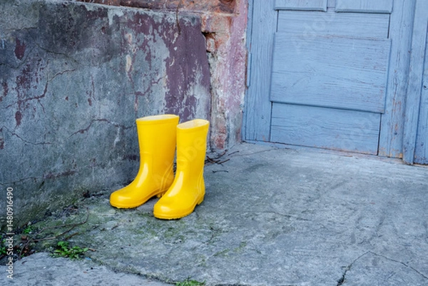 Obraz Two yellow rain boots are standing on a concrete sidewalk